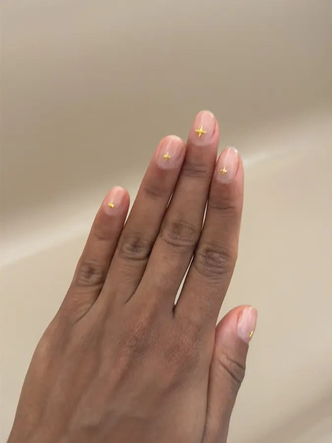 Nude-Nägel mit kleinen goldenen Sternen